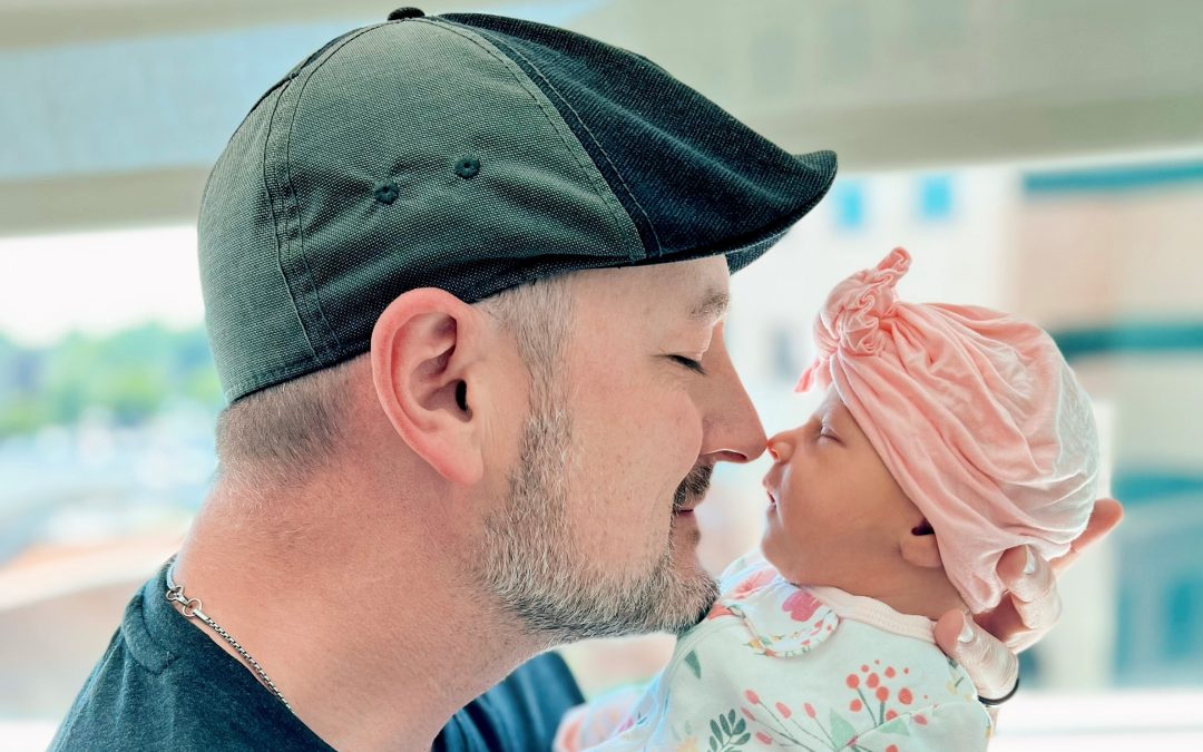 embryo adoption: bigger than us adoptive dad hold his nose to embryo adopted daughter